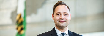 Landtagspräsident Alexander Dierks im Plenarsaal vor der Sachsenflagge