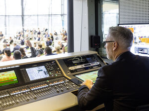 Techniker im Studio des Landtags mit Blick auf den gefüllten Plenarsaal