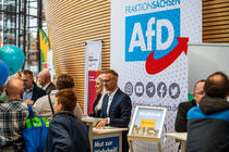 Am Stand der AfD stehen Menschen, die mit den stellvertretenden Abgeordneten der Fraktion ins Gespräch kommen.