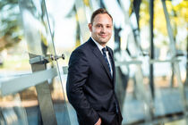 Landtagspräsident Alexander Dierks im Plenarsaal vor der Scheibe