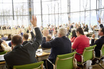 Abgeordnete im Plenarsaal heben die Hände zur Abstimmung.