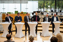 Die Abgeordneten der Diskussionsrunde stehen nebeneinander im Plenarsaal.