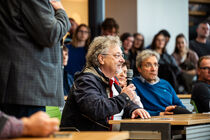 Ein Bürger mit Mikrophon stellt eine Frage an die Abgeordneten der Diskussionsrunde. 