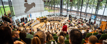 Zuschauertribüne mit Blick auf den Plenarsaal, in dem eine Gruppe tanzt