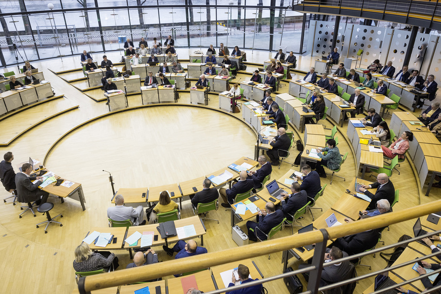 Blick von oben in den Plenarsaal, wo zahlreiche Abgeordnete während einer Plenarsitzung Platz genommen haben.