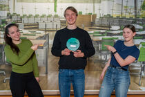 Die drei Gewinner posieren mit dem Pokal für den Erstplatzierten
