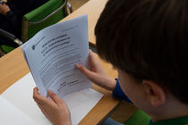 Ein Schüler ließt sich seine Teilnehmerinfo mit der Nummer 1 durch