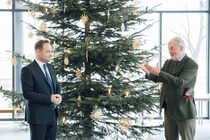 Der Landtagspräsident Alexander Dierks bekommt den Baum überreicht
