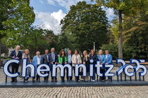Die Delegation positionoiert sich hinter dem Schriftzug Chemnitz 2025