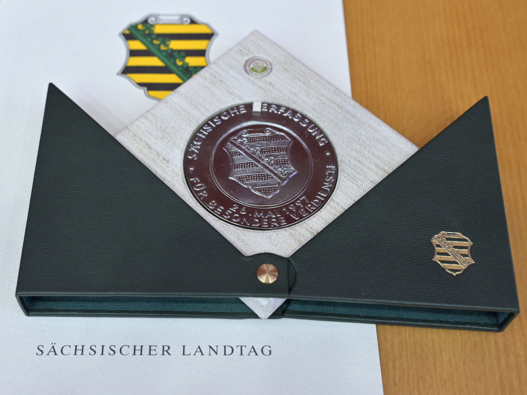 Verfassungsmedaille mit grüner geöffneter Schatulle und Urkunde mit dem Schriftzug Sächischer Landtag