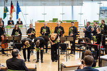 Ensemble verbeugt sich mit Blumen in den Händen.
