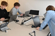 Schüler arbeiten praktisch am Computer unter Anleitung der Auszubildenden des Landtags.