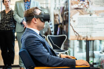 Landtagspräsident Alexander Dierks trägt eine VR-Brille und betrachtet etwas.