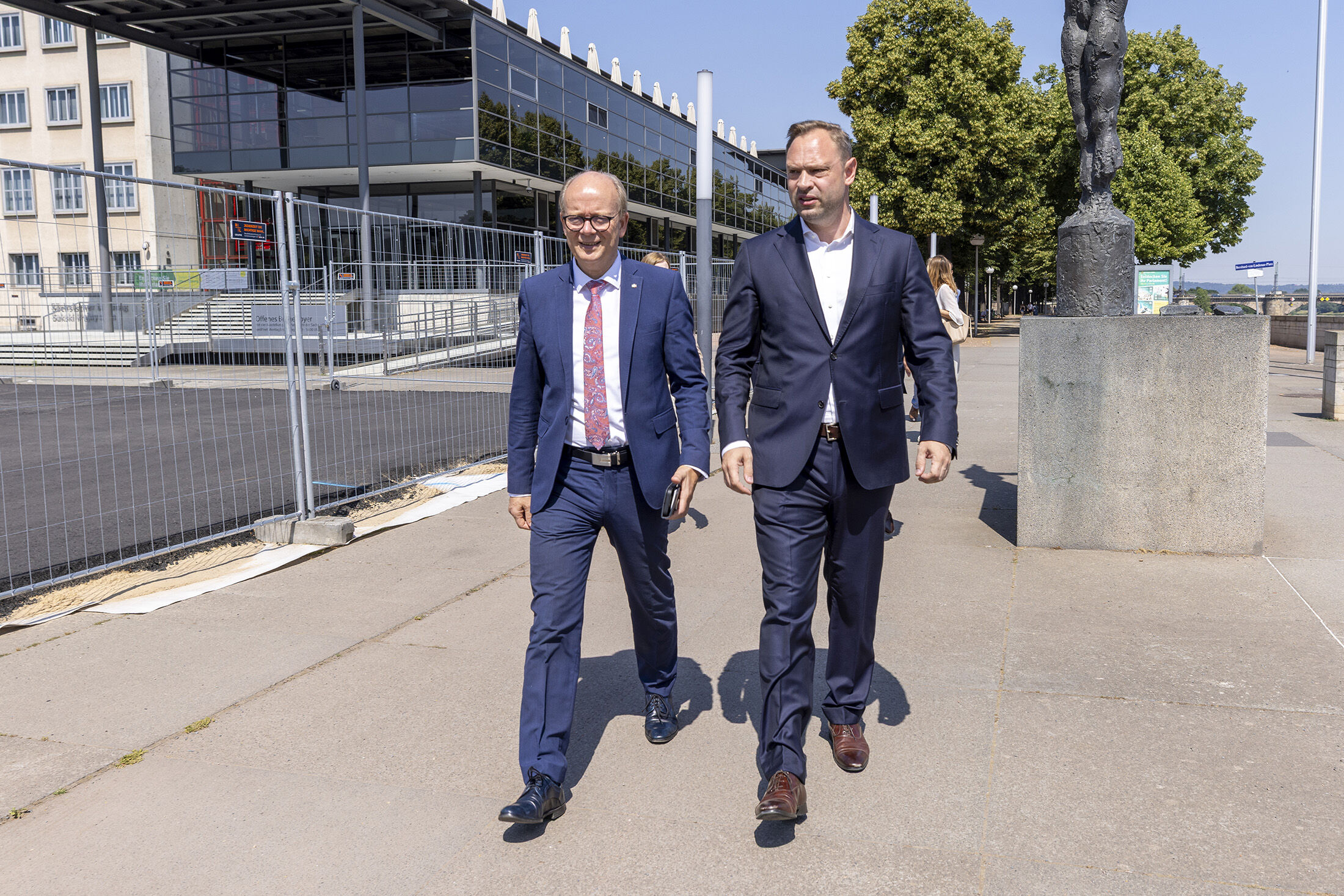 Die Landtagspräsidenten André Kuper und Alexander Dierks laufen nebeneinander. Im Hintergrund ist der Landtag zu sehen.