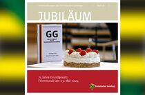 Auf einem Tisch stehen eine Ausgabe des Grundgesetzes sowie eine Torte.