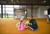 Zwei Kinder spielen im Bürgerfoyer im Neubau des Sächsischen Landtags mit der Haushaltswippe.